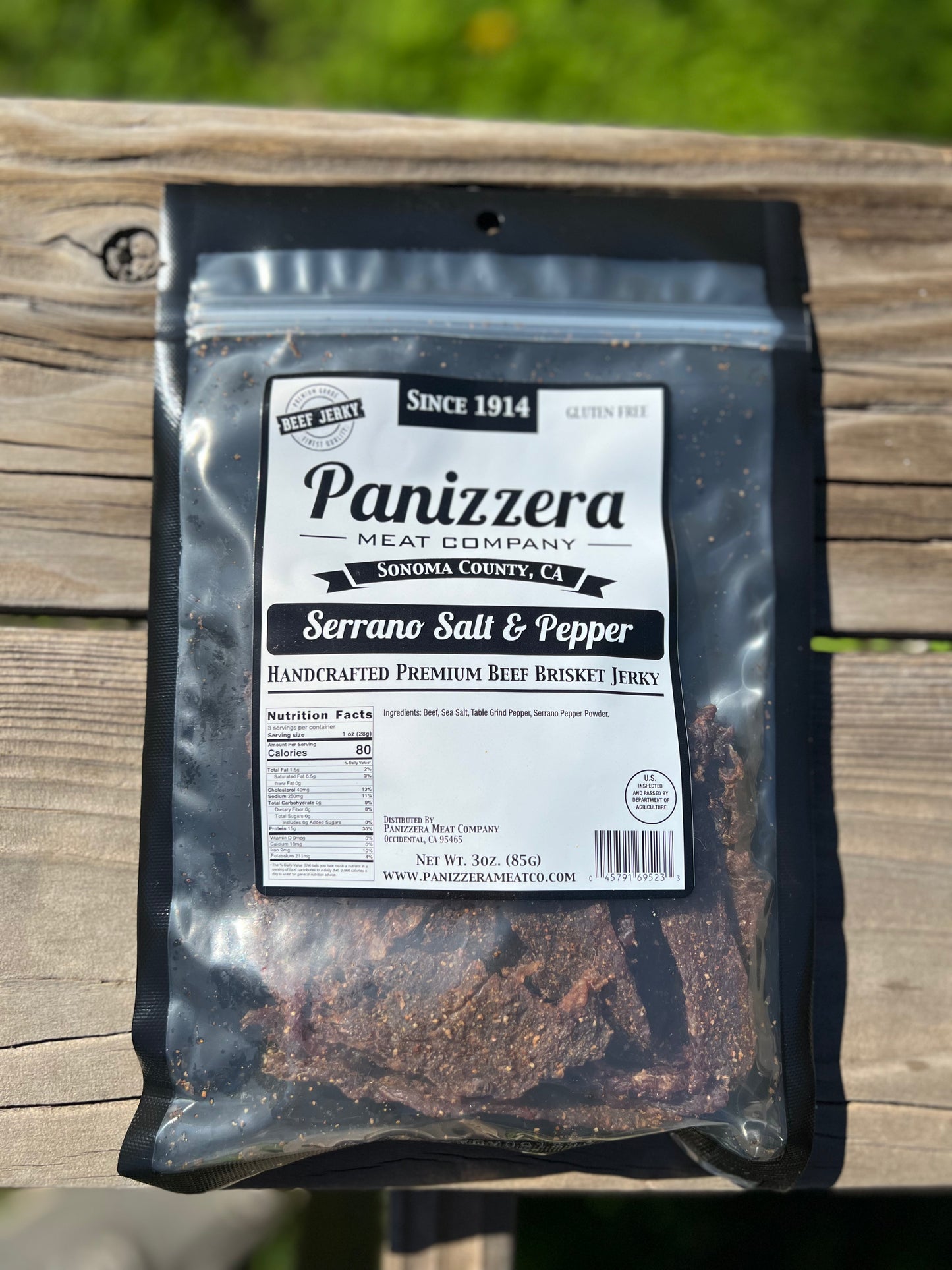 Packaged serrano salt and pepper beef jerky from Panizzera Meat Company on a wooden surface